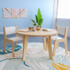 Whitney Brothers Whitney Plus Round Classroom Table - 22H, wooden children’s table with white top, set in a bright classroom with chairs and decorative wall art