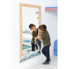 Moje Bambino Sea Waves Wall Mirror Decor, children playing with the ocean-themed mirror with a dolphin design in a bright playroom.