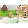 Moje Bambino Forest Floor Cushion, a soft, round green cushion in a children's playroom with kids playing and relaxing.