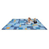 Playscapes Outside The Box™ Designer Classroom Carpet, a colorful geometric patterned carpet with a young girl lying on it and reading a book.