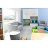 Moje Bambino Relax Round Ottoman, round upholstered ottoman in white and gray fabric, placed in a modern children's playroom with colorful seating and storage furniture.