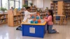 LiteZilla AeroCube Constructor Table - Blue, children build with colorful construction cubes at a blue activity table in a library.