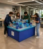 LiteZilla AeroCube Constructor Table - Blue, students build creative structures with blue and light blue construction cubes on a large interactive table in a school STEM classroom.
