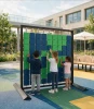 LiteZilla Mosaico Wall with Large Squares STEM Wall Activity, children arrange blue and green rotating squares on an outdoor interactive mosaic wall at a playground.