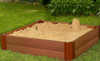 Frame It All Square Sandbox - 4' x 4' x 11" with sand and a sandcastle, outdoor backyard setting with green grass and plants.