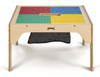 Jonti-Craft Wood DUPLO® Square Storage Table 27" x 27", light-colored wooden activity table with colorful DUPLO building blocks on top and a black mesh storage pocket underneath.