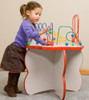 Playscapes Flower Shaped Bead Maze Activity Table, a young girl playing with a colorful bead maze on a flower-shaped activity table.