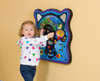 Playscapes Eco Drive Wall Toy, a colorful interactive wall-mounted activity toy with a steering wheel, gears, and moving parts for children to play with.