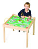Playscapes Road Trip Square Activity Table - 22" H, a young boy playing with a table-top game with a colorful road map design and miniature cars.