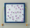 Playscapes Numbers Magnetic Educational Wall Activity, magnetic number and math operator tiles on a whiteboard framed in blue for kids learning.
