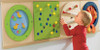 HABA Pro Colorful Squares Sensory Wall Activity, a young boy engaging with a sensory wall activity with colorful, textured panels designed for sensory play and development.
