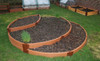 Frame It All Classic Sienna 4ft Curved Composite Board 2" Profile, installed as a garden bed border around soil-filled planting areas in a backyard garden.