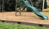 Frame It All Weathered Wood Straight Playground Border 16' - 1" Profile, brown wooden garden edging border around a children's play area with a slide and swings on a backyard playground. Frame It All Weathered Wood Straight Playground Border 16' - 1" Profile, brown wooden garden edging border around a children's play area with a slide and swings on a backyard playground.