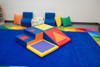 Children's Factory Shape and Play Foam Climbing Blocks, colorful foam climbing blocks set with geometric shapes for children's play and development on a blue carpet in a playroom.