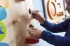 HABA Pro Motor Skills E Sensory Learning Wall Panel, Young child engaging with sensory wall panel for fine motor skill development.