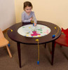 Playscapes Bees & Flowers Round Children's Activity Table, a young girl playing with fishing game on a circular interactive kids' table in a playroom.
