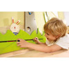 HABA Pro Tree and Animals Meadow Interactive Wall Decor, child playing with the green mountain-shaped decor featuring a rabbit figure on a wooden wall.