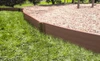 Frame It All Classic Sienna Straight Playground Border 16' - 1" Profile, wooden fencing for playground edging with mulch surface and green grass in the background.
