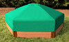 Frame It All Hexagon Sandbox with Collapsible Cover, outdoor wooden sandbox with green cover, placed on grass in a garden setting.