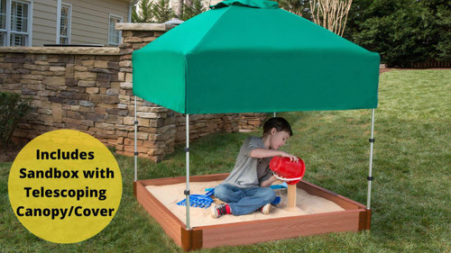 Frame It All Square Sandbox with Telescoping Canopy and Cover, 5.5H, outdoor sandbox with a green canopy in a backyard with a boy playing with sand and water in the sandbox.
