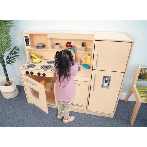 Whitney Brothers Contemporary Natural Play Kitchen Combo, a wooden play kitchen with stove, sink, and storage cabinets being used by a child.