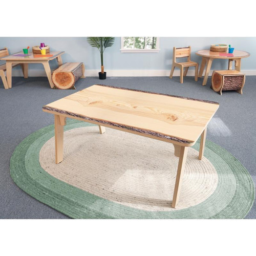 Whitney Brothers Nature View Live Edge Rectangle Table 22" H, wooden table with a natural live edge and smooth finish, in a light wood color, situated in a children's playroom with small furniture and colorful accessories.