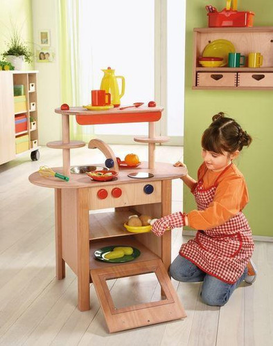 HABA Pro Mini Wooden Play Kitchen Block, children playing with a miniature wooden kitchen set in a bright, colorful playroom.