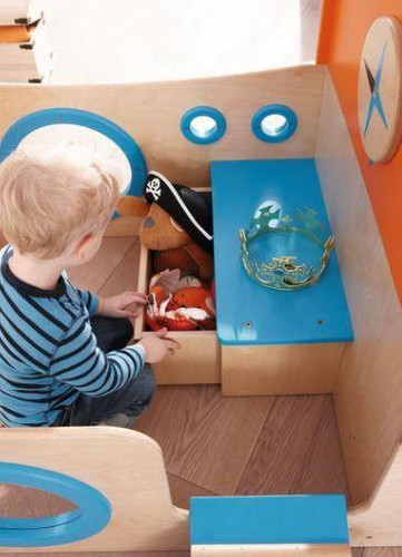 HABA Pro Play Wooden Sailboat Climber, a children's play area with a wooden sailboat-themed climbing set and toys for imaginative play.