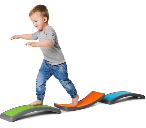 HABA Pro Balance See-Saw Set, young boy balancing on colorful curved balance equipment for kids.
