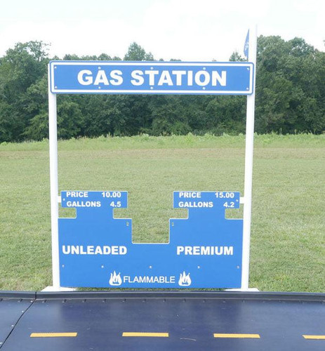 Infinity Playgrounds Gas Station Outdoor Playhouse, outdoor toy playhouse designed to look like a gas station sign with fuel prices for unleaded and premium gas, and flammable warning symbols.