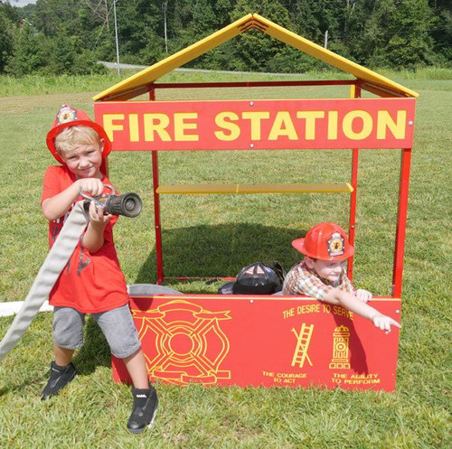 Infinity Playgrounds Fire Station Outdoor Playhouse, children playing with firefighter gear in a fire station-themed playhouse.
