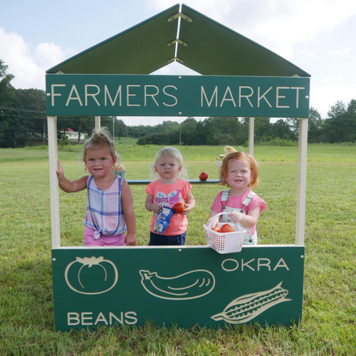 Infinity Playgrounds Farmers Market Outdoor Playhouse, children playing at a miniature farmers market stand with vegetables and a sign.