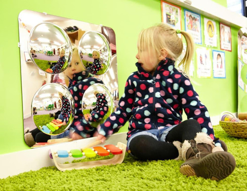 SPARK & WOW Acrylic Bubble Mirror - 4 Large Bubbles, a colorful reflective acrylic mirror with four large bubble-shaped mirrors and musical xylophone on a green carpet, child playing in a bright playroom.
