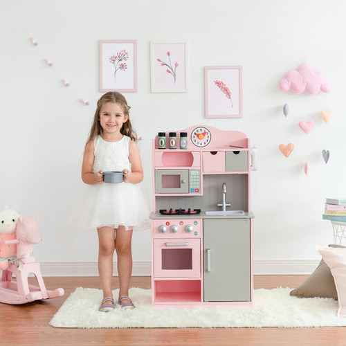 Teamson Kids Little Chef Florence Pink Play Kitchen with Accessories, a pink and gray pretend kitchen set for kids with stove, sink, microwave, and storage compartments in a child's playroom.