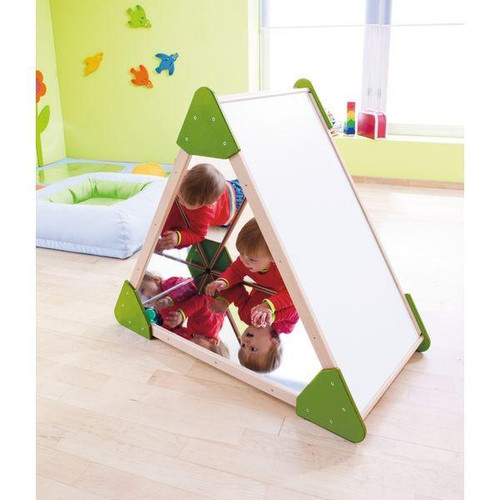 HABA Pro Mini Mirror Triangle House with Whiteboard, children's triangular mirror and whiteboard combo in a playroom with kids reflected in the mirror.