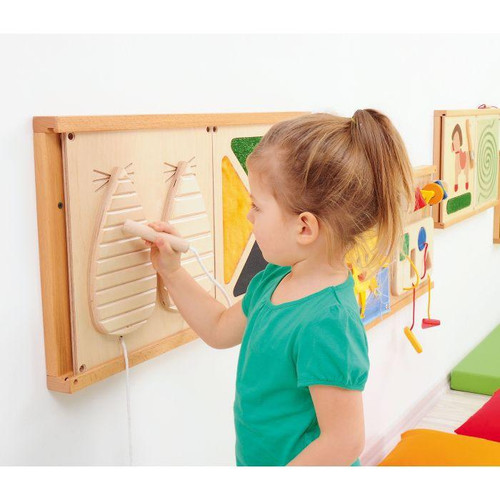 Moje Bambino House Fine Motor Skills Wall Panel, young girl playing with wooden balancing game on educational wall panel in a classroom or playroom.