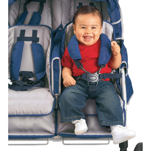 Angeles SureStop BYE-BYE Folding Commercial Stroller 6 Passenger, child sitting comfortably in a multi-passenger stroller with a smiling face, dressed in a red shirt, blue jeans, and white shoes, secured with a harness.