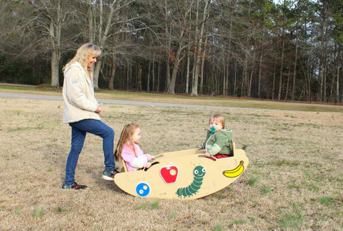 Infinity Playgrounds Slayden's Toddler SeeSaw, children playing on a colorful saw-shaped seesaw with a woman supervising outdoors in a park.