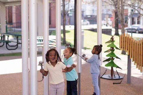 Freenotes Contrabass Outdoor Chimes, children playing and enjoying music with large outdoor musical chimes in a park setting.