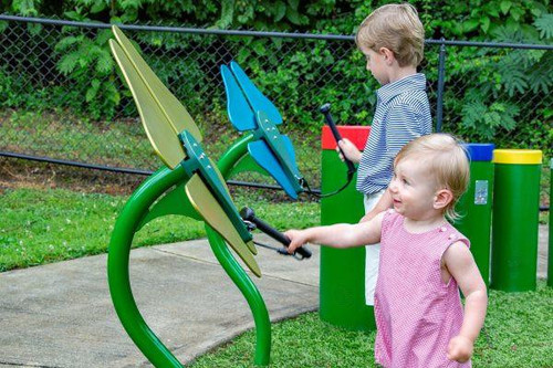 Freenotes Flower Musical Outdoor Bells, two children playing with colorful outdoor musical bells in a park.