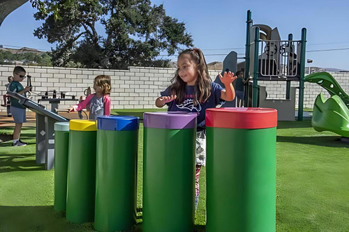 Freenotes Tuned Outdoor Congo Drums, colorful outdoor percussion instrument setup at a playground for children.