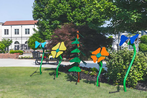 Freenotes Garden Bed Ensemble Musical Playground Set, colorful musical instruments including flowers and wind chimes in a green outdoor park setting.