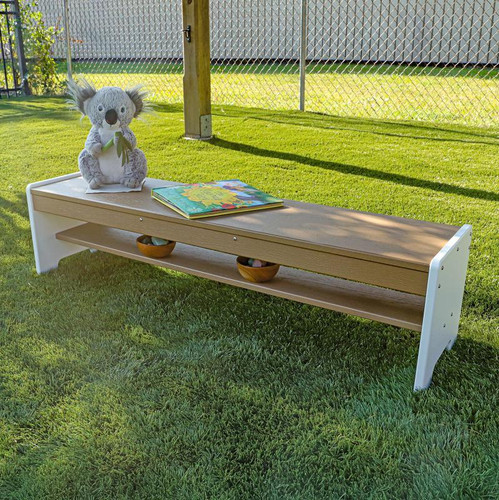 Whitney Brothers outdoorED™ Outdoor Bench, wooden outdoor children's bench with a white and natural wood finish, placed on a grassy outdoor area with a fence in the background.