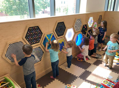 LiteZilla Multi-Sensory Hexagon Panel - Blue to Orange Sequin Flip Classic, children playing and interacting with colorful, illuminated hexagon sensory panels in a classroom setting.