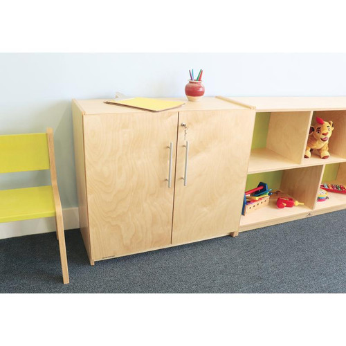 Whitney Brothers Whitney Plus Locking Storage Cabinet, wooden storage cabinet with doors and metal handles, used in a classroom or playroom setting.