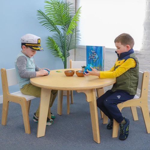 Whitney Brothers Whitney Plus Round Classroom Table - 22H, a light wood round table with two children sitting and playing around it in a bright classroom setting.