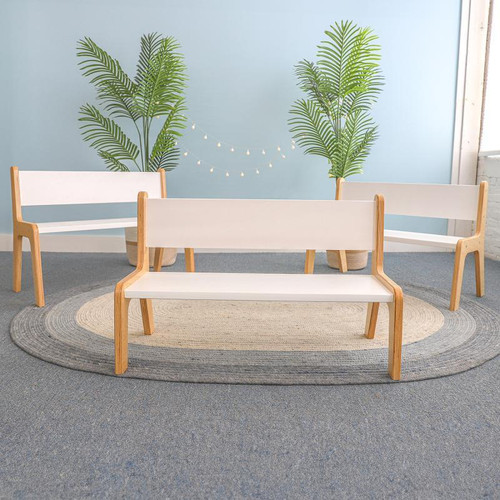 Whitney Brothers Whitney Plus White Bench - 10H, modern white wooden benches with natural wood legs in a bright room with green plants and decorative lighting.