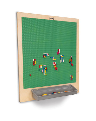 Jonti-Craft Building Brick Activity Wall, green pegboard with colorful building bricks arranged on it and a gray tray at the bottom for storage.