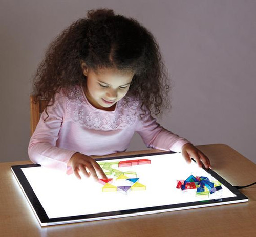 Jonti-Craft Illumination Light Tablet, young girl playing with colorful geometric shapes on the illuminated light table.