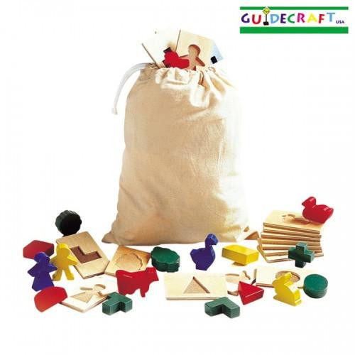 Guidecraft 3D Feel & Find Wooden Puzzle Set, educational wooden puzzle pieces and wooden figures arranged in front of a cloth bag for learning shapes and textures. Guidecraft 3D Feel & Find Wooden Puzzle Set, educational wooden puzzle pieces and wooden figures arranged in front of a cloth bag for learning shapes and textures.